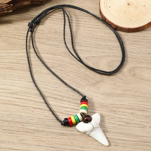 Macro detail of shark tooth pendant with colorful beads and black adjustable cord