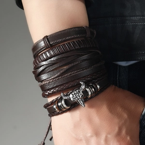 Detail view of multilayer braided brown leather bracelet with vintage metal bull head charm