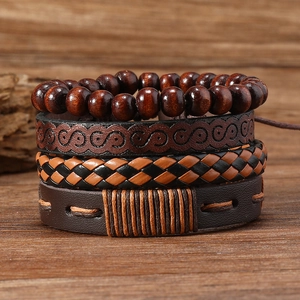 Makroansicht der vierteiligen Leder- und Holzperlenarmbänder auf einer rustikalen Holzfläche