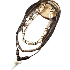 Multi-layer beach necklace featuring natural cowrie shells and white shark tooth pendant