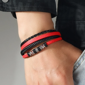 Detail of multi-layer dragon leather bracelet with red woven bands and magnetic metal clasp