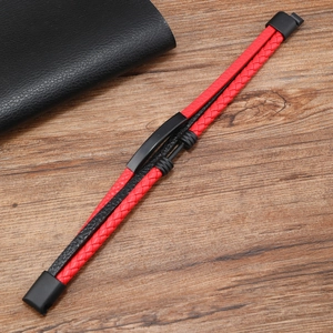 Detail showing red and black braided leather strands with a matte black metal clasp