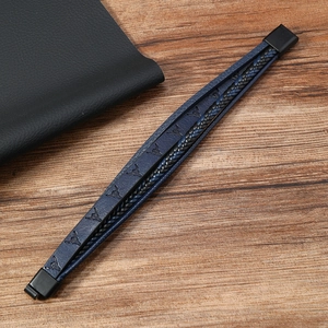Close-up of men's leather bracelet with bull head imprint and magnetic metal clasp