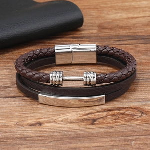 Detail of men's leather multi-layer bracelet featuring a silver dumbbell charm and braided cord