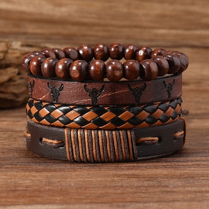 Nahaufnahme von Vintage Lederarmbändern mit Holzperlen und Stierkopf-Prägung für Herren