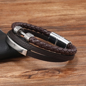Detail of multi-layer brown leather bracelet featuring woven rope and a silver dumbbell charm