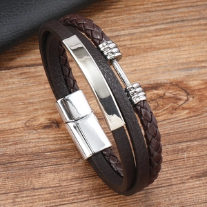 Detail of men's brown braided leather bracelet with silver metal plate and magnetic clasp
