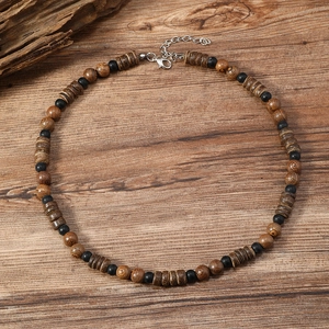 Detalle de collar bohemio hecho a mano con cuentas de madera y cierre de plata en madera