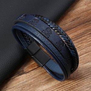 Détail d'un bracelet en cuir bleu multicouche avec motif crâne et fermoir magnétique noir