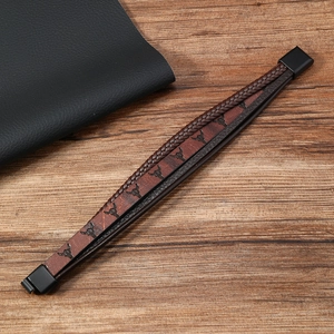 Detail of western braided leather bracelet with bull head motif and magnetic metal clasp
