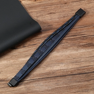 Détail des cordons en cuir multicouches et du motif de crâne sur le bracelet punk pour homme