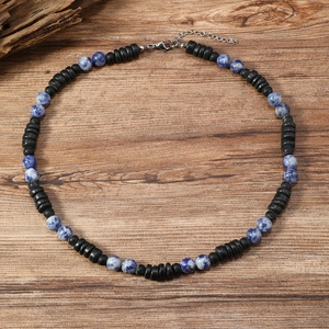 Detalle del collar bohemio de madera de coco y piedras azules sobre fondo madera
