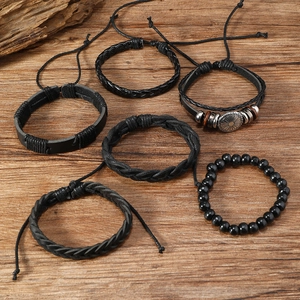 Macro detail of a 6-piece men's leather bracelet set with metallic charms and beads