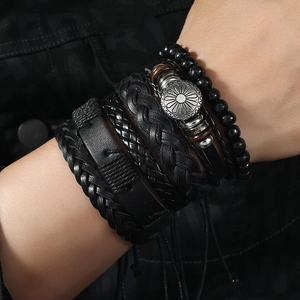 Detail of 6-piece men's multilayer black leather bracelet set with metallic accents