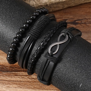 Close-up of a 4-piece vintage black leather bracelet set with infinity metal charm