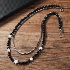 Détail du collier double couche pour homme avec perles noires mates et chaîne en argent