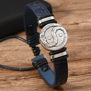 Macro shot of silver Tai Chi dragon charm on dark blue braided leather men's bracelet