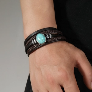 Detailed view of multilayer leather bracelet featuring a turquoise stone on a model wrist