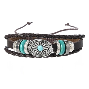 Détail d'un bracelet multi-rangs en cuir avec pierre turquoise et breloque en métal