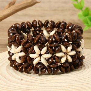 Détail d'un large bracelet bohème avec des perles en bois marron foncé et crème