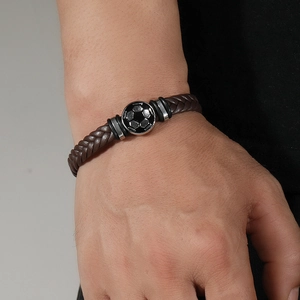 Geflochtenes dunkelbraunes Leder-Fussballarmband mit Metallanhänger am Handgelenk