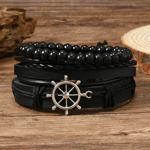Retro multi-layer black leather bracelet set featuring silver rudder charm on wood surface