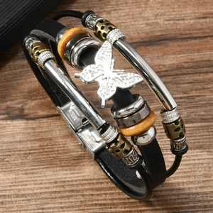 Detail der Edelstahl-Schließe und Vintage-Schmetterlingsanhänger auf dem Lederarmband