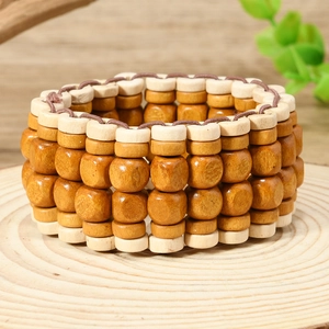 Détail de bracelets bohèmes multicouches en perles de bois naturel sur disque de bois