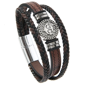 Detail of multi-layer braided leather bracelet with vintage silver anchor charm and magnetic clasp