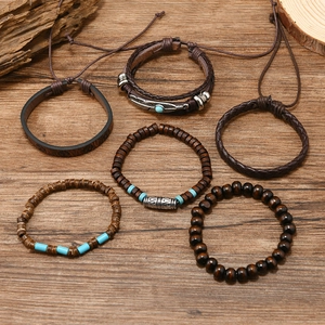Handmade 6-piece bohemian beaded leather bracelet set with feather charms on wood