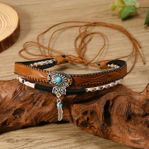 Vintage bohemian necklace with turquoise silver feather pendant on a rustic wood base