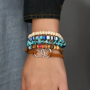 Bohemian multi-layer wood bead bracelets set with heart charms on denim jacket background