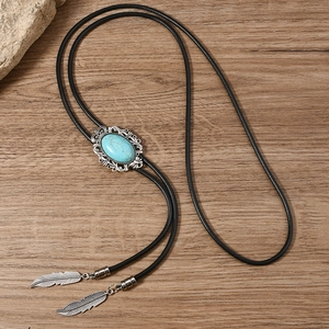 Close-up of vintage Bolo Tie with oval turquoise stone and silver feather metal pendants