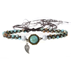 Detail of vintage turquoise beaded necklace with sun-motif base and silver leaf pendant