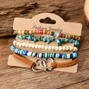 Close-up of five-piece bohemian stacked bracelets with wood beads and heart charms