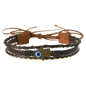 Detail of multi-layer braided hamsa hand bracelet with blue evil eye bead and bronze finish
