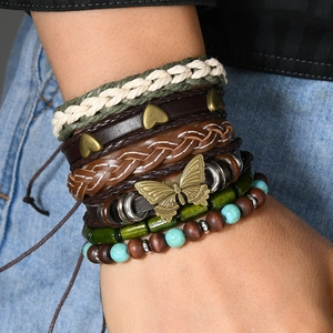 Detail of bohemian layered bracelets with leather, turquoise beads and butterfly charms