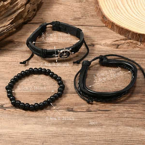 Detail view of 3pcs set men's braided leather bracelets with helm charm on wood background