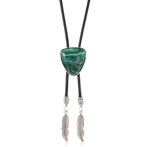 Bolo Tie Detail mit grünem Dreiecksstein und verzierten Federspitzen aus Silber