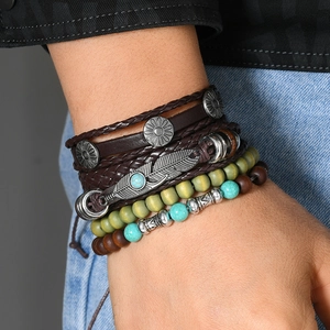 Close-up of Bohemian multilayer bracelet set with turquoise beads and feather charm