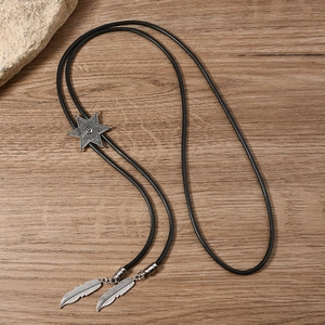 Close-up of star metal slide and silver feather pendants on a vintage bolo tie