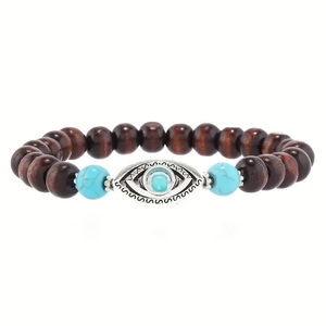 Macro detail of wooden beads bracelet featuring an intricate silver Evil Eye charm