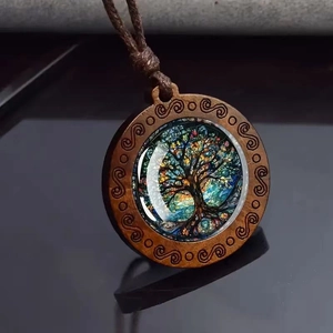 Détail du collier pendentif en bois avec arbre de vie en verre et gravures en spirale