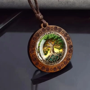 Détail macro du pendentif Arbre de Vie en bois avec arbre vert et cœur en résine