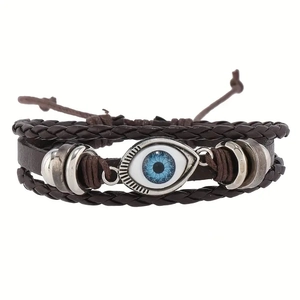 Macro detail of multi-layer leather bracelet with evil eye charm and braided ropes
