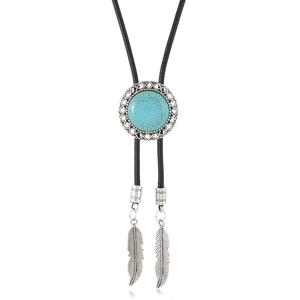Detailed macro view of retro western bolo tie featuring turquoise stone and silver feathers