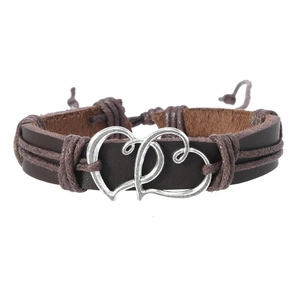 Gros plan du bracelet en cuir marron vintage avec cœurs entrelacés et détails tressés