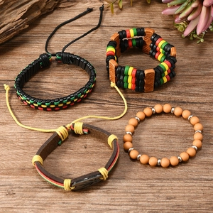 Detail view of four-piece Rasta style woven and beaded bracelets on a natural wood surface