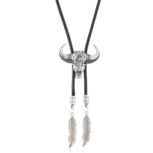 Vintage steer skull bolo tie with engraved cross patterns and black braided cord