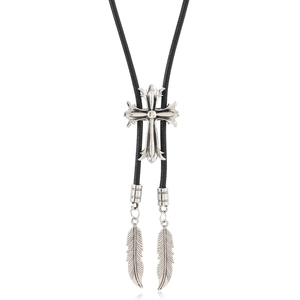 Macro view of silver Gothic cross slider and woven leather cord on retro bolo tie